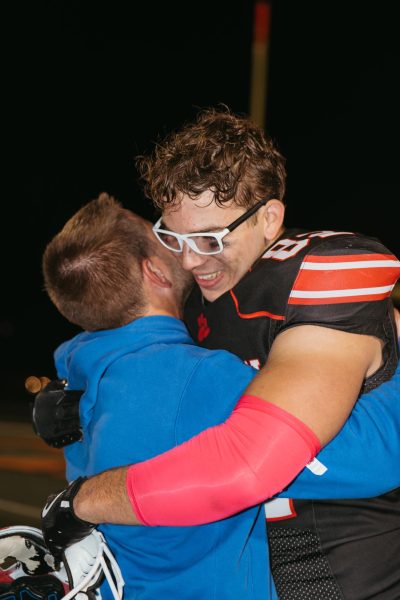 Hughey hugs coach Peter Kilburg on senior night.