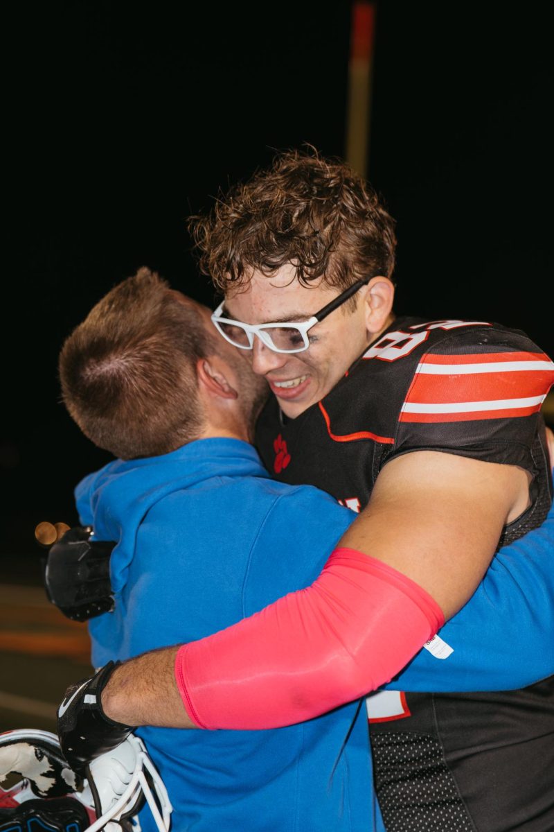 Hughey hugs coach Peter Kilburg on senior night.