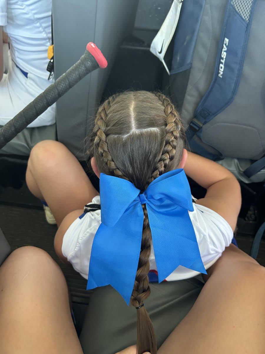 Addy does Haley Lang's hair on the bus for a softball game in Denison-Schleswig