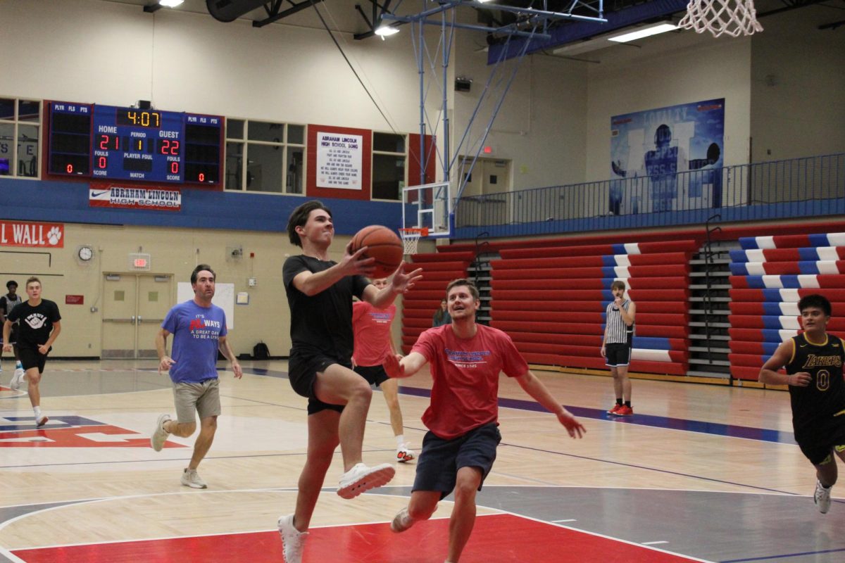 Senior CJ Walton doing a layup on teacher Hunter Hendrix